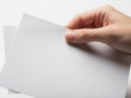 A hand holding a stack of blank white paper sheets isolated on white background Royalty Free Stock Photo