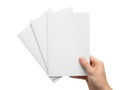 A hand holding a stack of blank white papers with a pencil on a white background Royalty Free Stock Photo