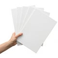 A hand holding a stack of blank white sheets of paper against a plain background Royalty Free Stock Photo