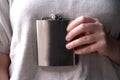 Hand holding a stainless steel hip flask for liquor, alcohol and drink concept close-up