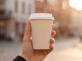 Hand holding a steaming hot coffee cup outdoors in sunlight Royalty Free Stock Photo