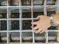 Hand holding on the steel sieve on footpath, steel grating