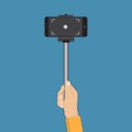 Hand holding stick selfie with smartphone in a flat design