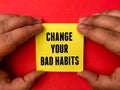 Hand holding sticky notepaper with text CHANGE YOUR BAD HABITS Royalty Free Stock Photo