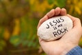 Hand holding a stone with handwriting Jesus is My Rock in nature Royalty Free Stock Photo