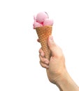 Hand holding an strawberry or cherry ice cream scoops with cone isolated on white background. Royalty Free Stock Photo