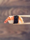 Hand holding sushi roll using chopsticks Royalty Free Stock Photo