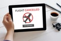 Hand holding tablet with flight cancelled concept on screen