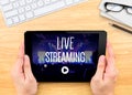 Hand holding tablet with Live Streaming word on wood table ,Internet marketing concept. Royalty Free Stock Photo