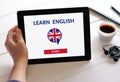 Hand holding tablet with online learn English concept on screen Royalty Free Stock Photo