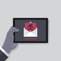 Hand holding tablet screen concept. businessman read alert notification. Phishing attack email with skull and bones, email symbol