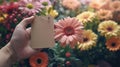 A hand holding a tag with flowers in the background, AI Royalty Free Stock Photo