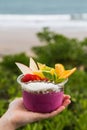 Hand holding a takeaway acai bowl with fresh fruit and mint leaves Royalty Free Stock Photo