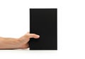 Hand holding a tall black rectangular object against a clean white surface isolated on white background Royalty Free Stock Photo
