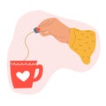 Hand holding tea bag and tea cup. Royalty Free Stock Photo