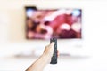 Hand holding television and audio multimedia remote control for watching tv