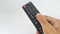 Hand holding television remote control on white background Royalty Free Stock Photo