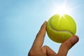 Hand holding tennis ball up to the sky Royalty Free Stock Photo