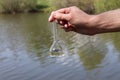 hand holding test tube for analyses with water on the background of the reservoir, the concept of water purity, pollution of water Royalty Free Stock Photo