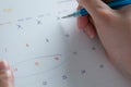 A hand holding Thai calendar and right hand using a pen cross out a date in April for the countdown to Songkran festival