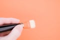 Hand holding a thick painting brush on orange background for a copy space Royalty Free Stock Photo