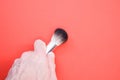 Hand holding a thick painting brush on red background for a copy space Royalty Free Stock Photo