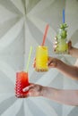 Hand holding three smoothie shake cocktails against a wall. Drinking red healthy smoothie concept. Seasonal cocktail Royalty Free Stock Photo