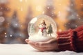 Hand holding Tiny cute christmas contained within a sphere glass bottle on snow background Royalty Free Stock Photo