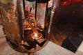 Hand holding to light the red incense with flame of candle in the temple. Ritual, belief an Royalty Free Stock Photo