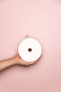 Holding Toilet roll with pink background