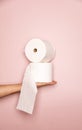 Holding 2 Toilet rolls with pink background