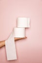 Holding 2 Toilet rolls with pink background