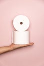 Holding two Toilet rolls with pink background