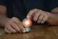 Hand holding and touching the light bulb on a wood table, new idea concept with innovation and inspiration Royalty Free Stock Photo