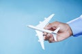 Hand holding toy plane over blue background Royalty Free Stock Photo