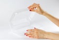 Hand holding transparent plastic container. Close up. Isolated o Royalty Free Stock Photo