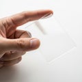 A hand holding a transparent rectangular object against a plain background Royalty Free Stock Photo