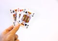 Hand holding a trio of king cards of poker over a white background