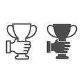 Hand holding trophy cup line and solid icon, sports concept, golden goblet sign on white background, cup icon in outline Royalty Free Stock Photo