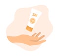 A hand holding a tube of sunscreen on a white background. Vector illustration