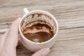 Hand holding Turkish coffee cup for fortune telling from shapes of the coffee grounds Royalty Free Stock Photo