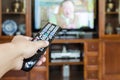 Hand holding TV remote control with television Royalty Free Stock Photo