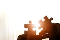 Hand holding two pieces of jigsaw connecting couple puzzle against sunrise effect Royalty Free Stock Photo