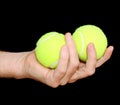 Hand Holding Two Tennis Balls isolated on black Royalty Free Stock Photo