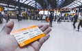 Hand holding UK Rail Return Ticket in Brighton & Hove train station