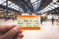 Hand holding a UK train ticket at Brighton & Hove train station for background in Brighton, England.