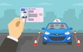 Hand holding a United Kingdom car driver license identification. Blue right-hand driving vehicle with red L plate on a roof. Royalty Free Stock Photo