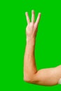 Hand Holding Up Three Fingers Against Bright Green Background Royalty Free Stock Photo
