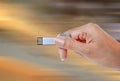 Hand holding USB data storage against bright light and circuit Royalty Free Stock Photo