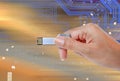 Hand holding USB data storage against light and circuit Royalty Free Stock Photo